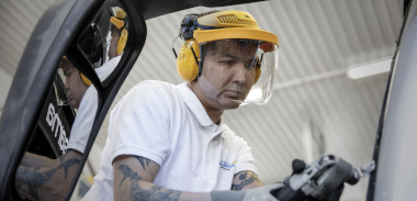 En person med verneutstyr reparerer en buss