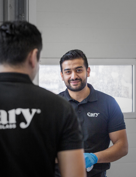 To personer står overfor hverandre, den ene med ryggen mot kameraet i en verkstedhall